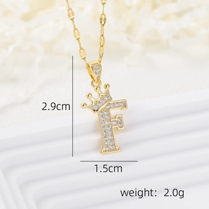 Macro shot of 18k gold plated letter F pendant with crown and white cubic zirconia