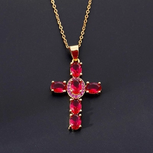 Collana con croce dorata con gemme rosse ovali e zirconi viola su sfondo nero opaco