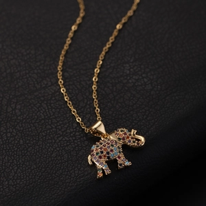 Macro shot of gold elephant pendant with colorful cubic zirconia on black leather