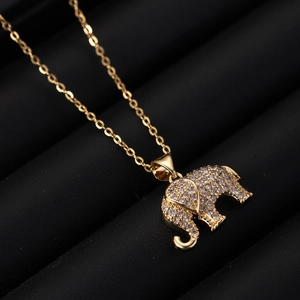 Close-up of golden elephant pendant with micro-paved white zircons on a black tray