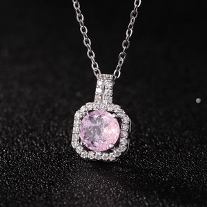 Nahaufnahme von Silberanhänger mit rosa Zirkon, umgeben von weißen Diamanten