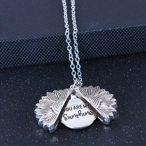 Détail du collier tournesol ouvrant avec gravure YOU ARE MY SUNSHINE à l'intérieur