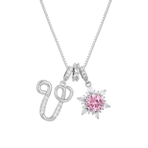 Macro detail of silver necklace with crystal letter U and pink floral snowflake pendant
