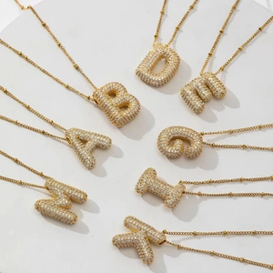 Detail of gold-plated bubble letter pendants with sparkling micro-pave cubic zirconia