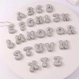 Macro detail of 3D silver bubble alphabet pendants with sparkling pavé cubic zirconia