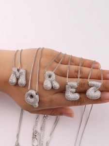 Detailed macro view of 3D bubble letter pendants with sparkling white cubic zirconia