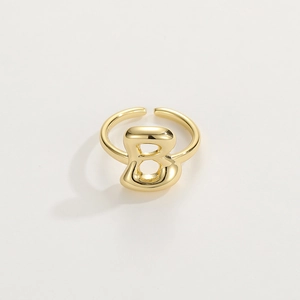 Dettaglio di un anello in oro 18K con lettera B, finitura lucida e fascia aperta regolabile