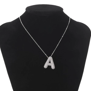 Macro view of silver bubble letter A pendant with clear zircon on black jewelry bust