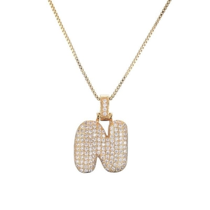 Détail de pendentif lettre N bulle avec pavé de zircons blancs et placage doré