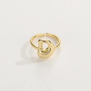 Macro di un anello aperto placcato oro 18K con design a forma di D lucido e astratto