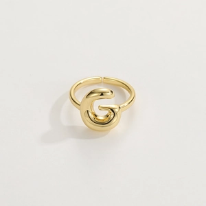 Dettaglio di un anello regolabile placcato oro 18 carati con un vistoso design a lettera G