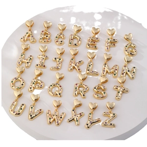 Golden alphabet necklace set with colorful zircon heart charms on a display stand