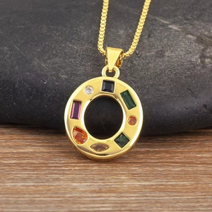 Detalle de collar con colgante redondo dorado y ocho circonitas de colores variados