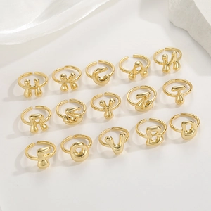 Dettaglio di anelli con lettere regolabili placcati oro 18K con finitura stile palloncino