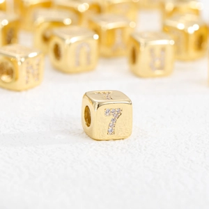 Dettaglio di un cubo placcato oro 18k con il numero 7 intarsiato di zirconi cubici