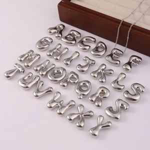 Polished silver balloon initial necklace set with letter E on a dainty metal chain