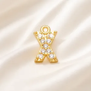 Detailed macro view of a gold-plated letter X charm with micro-paved white cubic zirconia