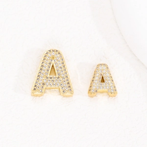 Dettaglio dei ciondoli con lettera A placcati in oro 18K con micro-pavé di zirconi cubici