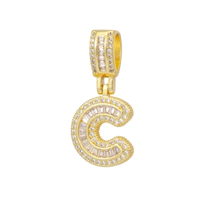 Macro detail of 18k gold plated letter C pendant with shimmering cubic zirconia stones