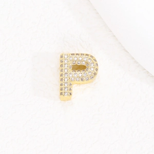 Dettaglio di un piccolo ciondolo a lettera P placcato oro 18K con micro-zirconi lucidi