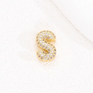 Dettaglio macro del ciondolo lettera S placcato oro 18K con micro-pavé di zirconi