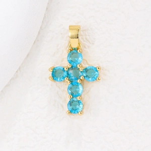 Makroaufnahme von 18k Gold-Kreuzanhänger mit sechs himmelblauen Zirkonia auf Textur