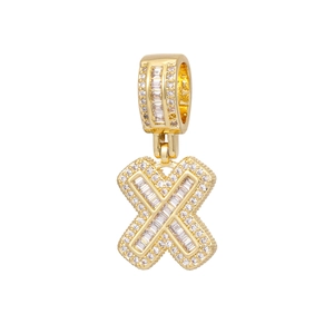 Macro detail of 18k gold plated letter X pendant with baguette and round cut zircons