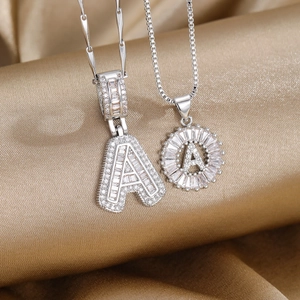 Pendentifs lettre A argentés sertis de zircons brillants sur tissu en soie dorée élégante