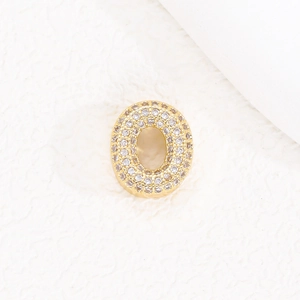 Dettaglio del ciondolo lettera O placcato oro 18K con micro-pavé di zirconi bianchi