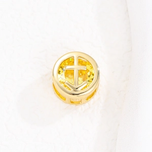 Vista detallada del colgante dorado con gema amarilla y diseño de ancla para collar