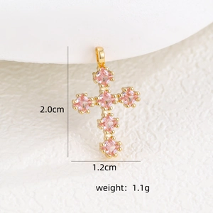 Vue macro d'un pendentif croix doré avec zircons roses et dimensions du produit
