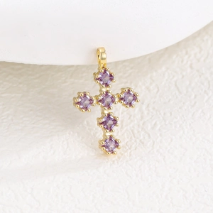 Vue détaillée d'un pendentif croix en or avec six zircons carrés violets éclatants