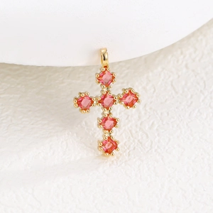 Vue macro d'un pendentif croix dorée vintage avec zircons roses de coupe carrée