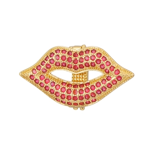 Detailed macro view of a red rhinestone encrusted lip brooch with golden alloy plating