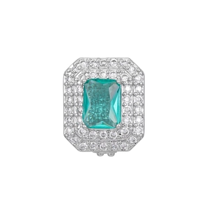 Macro detail of emerald-cut green gemstone with double halo diamonds on silver band