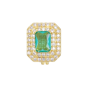 Macro detail of emerald-cut green gemstone with double halo diamonds in gold plating