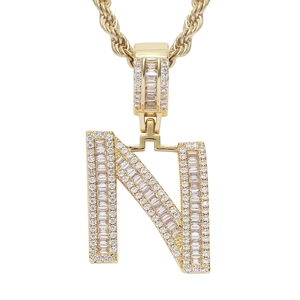 Macro shot of hip hop letter N pendant in gold with baguette and pave zircon stones
