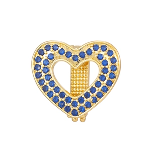 Detailansicht eines goldenen Herzanhängers mit blauen Strasssteinen und Hohlraum-Design