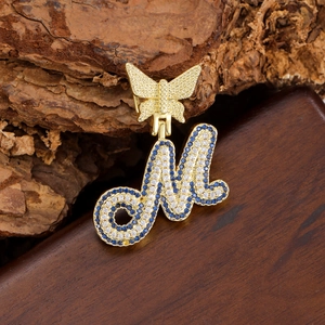 Golden butterfly necklace with letter M pendant featuring blue and white zircon stones