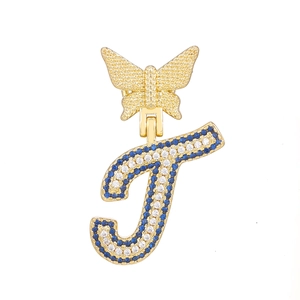 Close-up of gold butterfly pendant with blue and white crystals on letter J charm