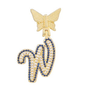 Close-up of golden butterfly necklace with blue and white pavé cursive letter W