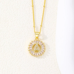 Macro shot of 18K gold letter A pendant with baguette zircons on a beaded chain