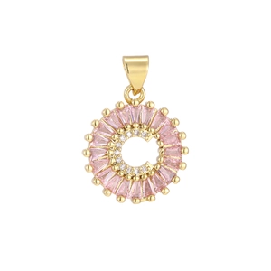 Macro shot of gold-plated pendant with pink baguettes and zircon letter C detail
