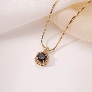 Detalle de la cadena dorada y colgante de frasco de perfume con piedra de circón púrpura