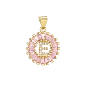 Macro detail of round letter E pendant with pink zircon border and gold plating
