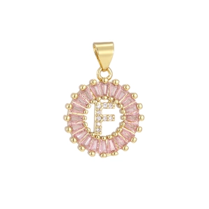 Detailed close-up of pink crystal letter F pendant with gold plating and zircon inlay