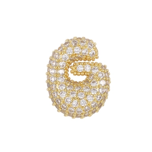 Detailed close-up of 18k gold letter G pendant with micro-paved sparkling zircon stones