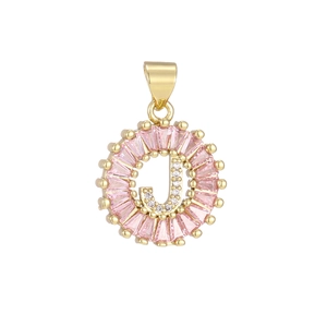 Detailed close-up of a gold pendant featuring a pink crystal border and diamond-set letter J