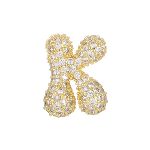 Macro detail of 18k gold letter K pendant with sparkling pave-set cubic zirconia