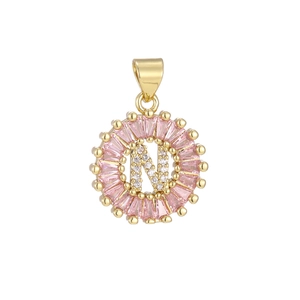 Detailed macro view of gold letter N pendant with pink zircons and crystal stones